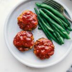 Ready-to-eat mini turkey meatloaves next to green beans.