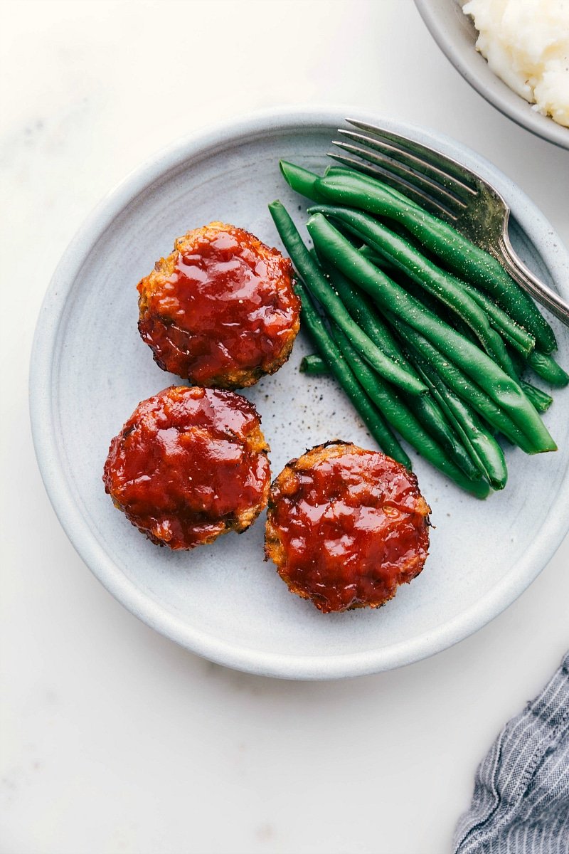 Overhead image of ready-to-eat mini Turkey Meatloaves next to green beans.