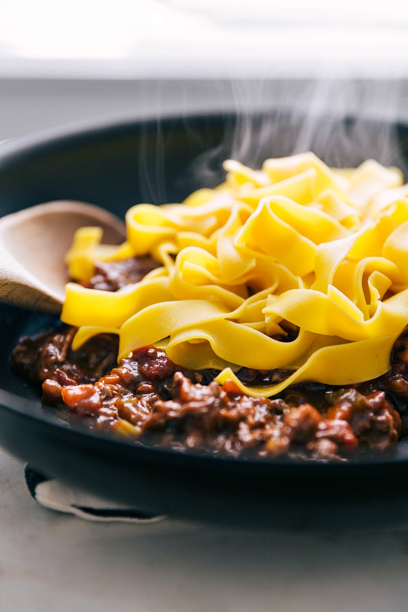 Image of the pappardelle pasta being served over the Beef Ragu.