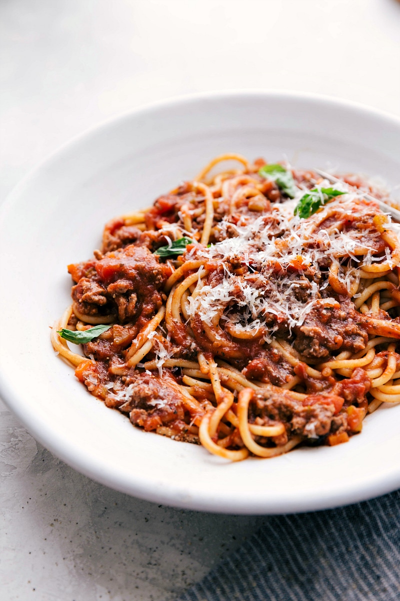 Large bowl of spaghetti bolognese with parmesan cheese on top