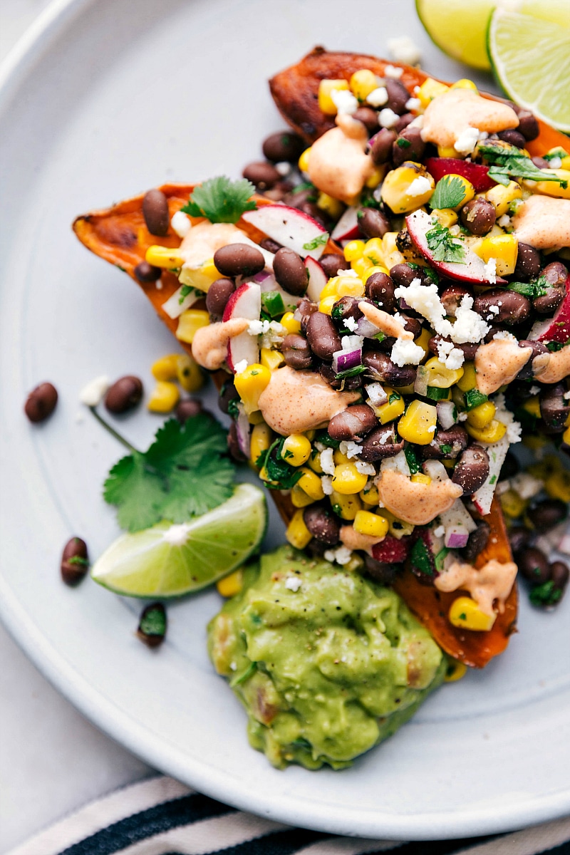 Baked sweet potato covered in toppings with a side of avocado sauce--Yum!