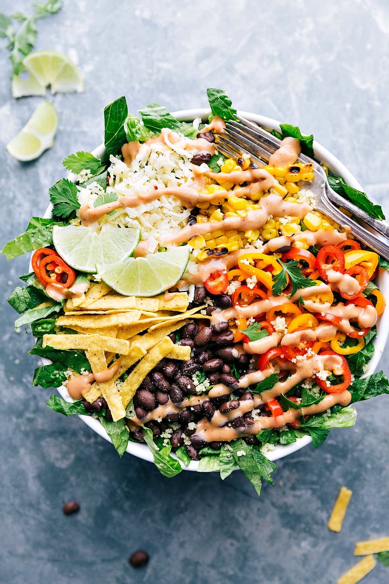 Overhead image of the ready-to-eat Black Bean Corn Salad with the dressing over it and a fork on the side.