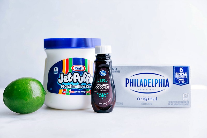 Image of all the ingredients that go in this recipe--lime, marshmallow fluff, coconut extract, and cream cheese.