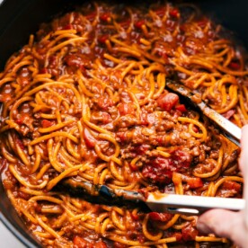 Taco Spaghetti in a pot with tongs about to scoop some up.