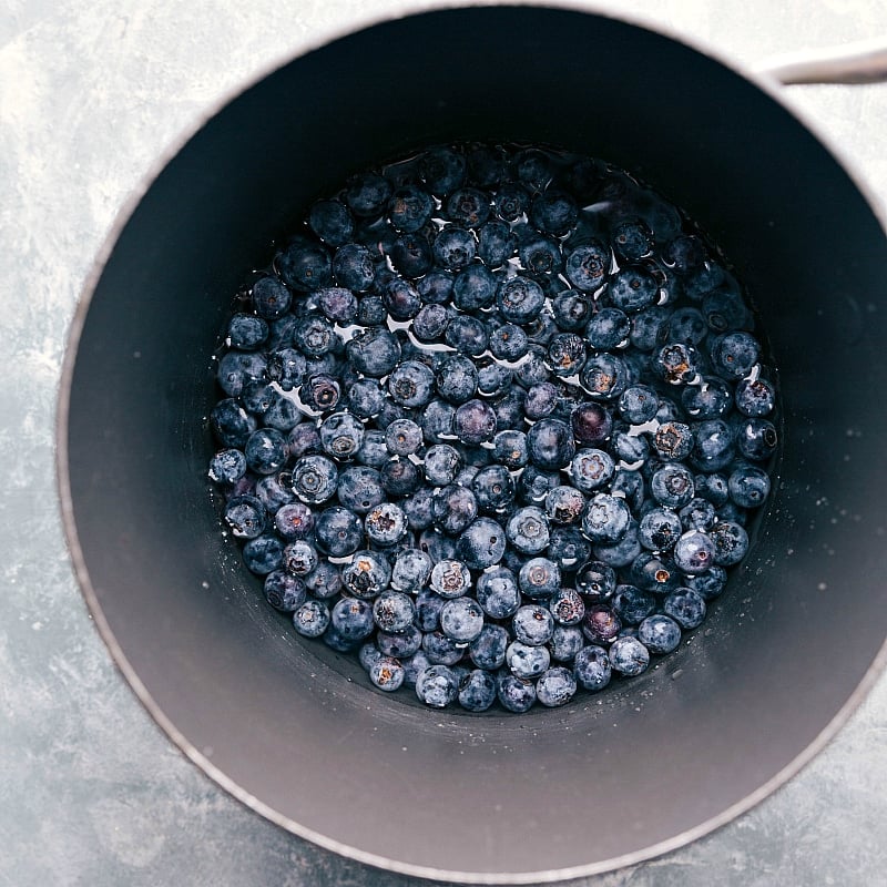 Image of fresh berries being added to a sauce pan.