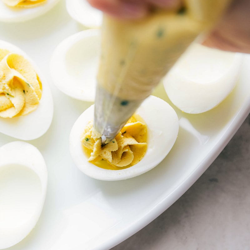 Image of the filling being pipped into the eggs making the best Deviled Eggs.