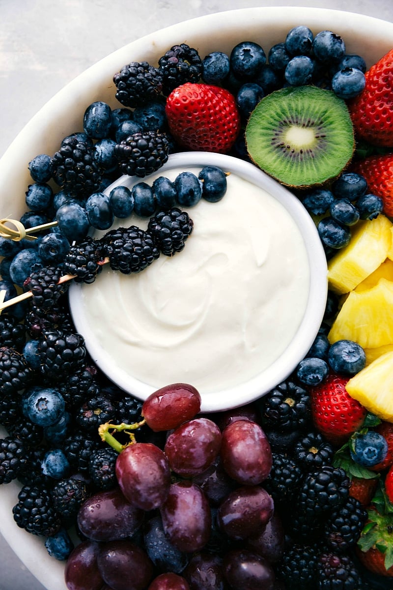 Up-close image of the cream cheese Fruit Dip recipe with a variety of fruit around it.