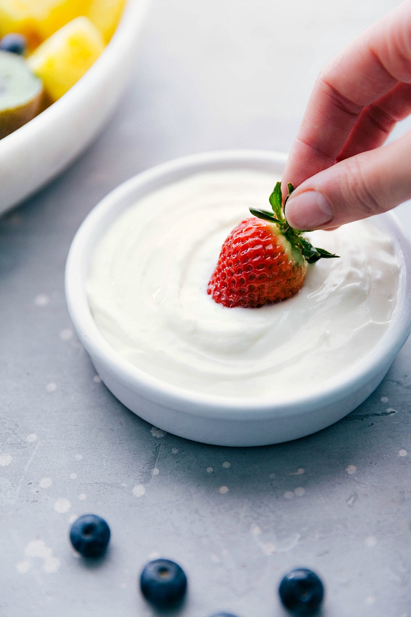 Image of a strawberry being dipped into Fruit Dip.