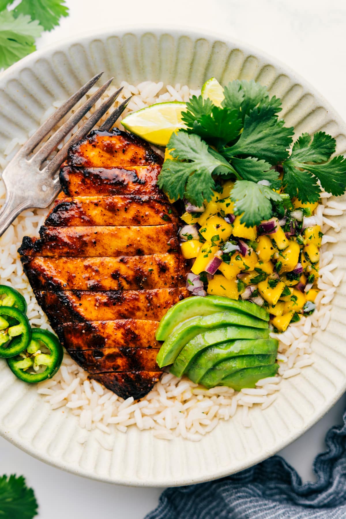 The Perfect Summer Dinner: Mango Chicken Mango Chicken on a bed of rice, served with mango salsa and topped with fresh cilantro.