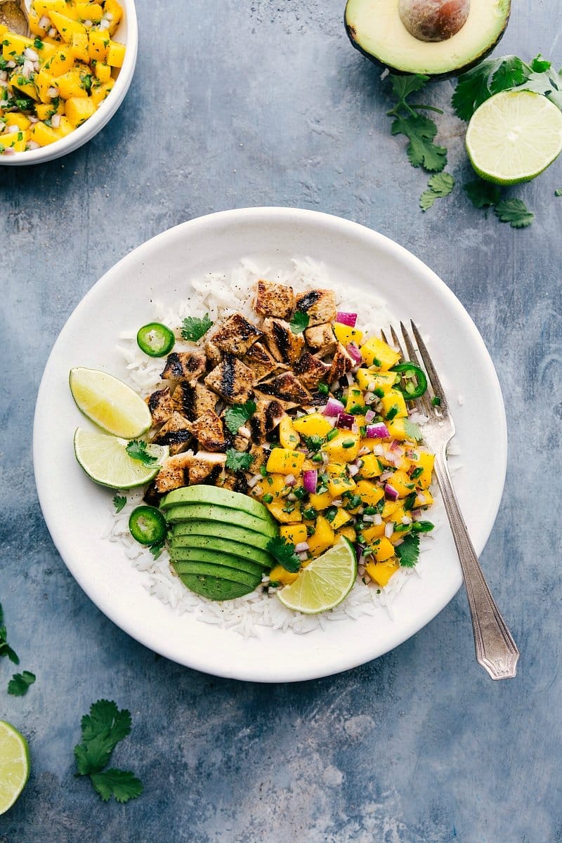 Overhead photo of finished Mango Chicken with sliced avocado and fresh lime.