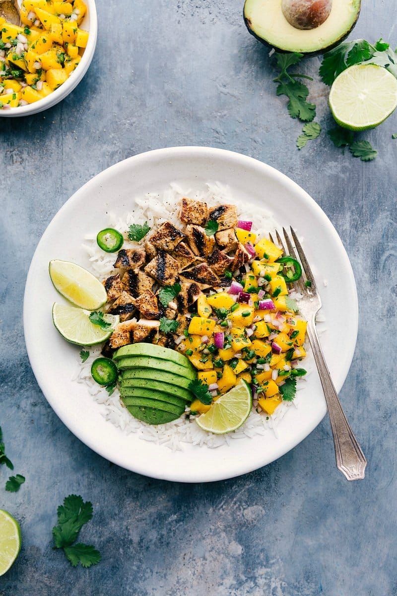 Overhead photo of finished Mango Chicken with sliced avocado and fresh lime.