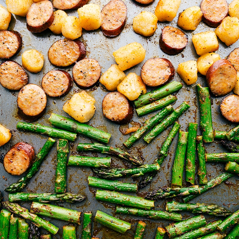 Asparagus is added to sheet pan partway through the baking time.