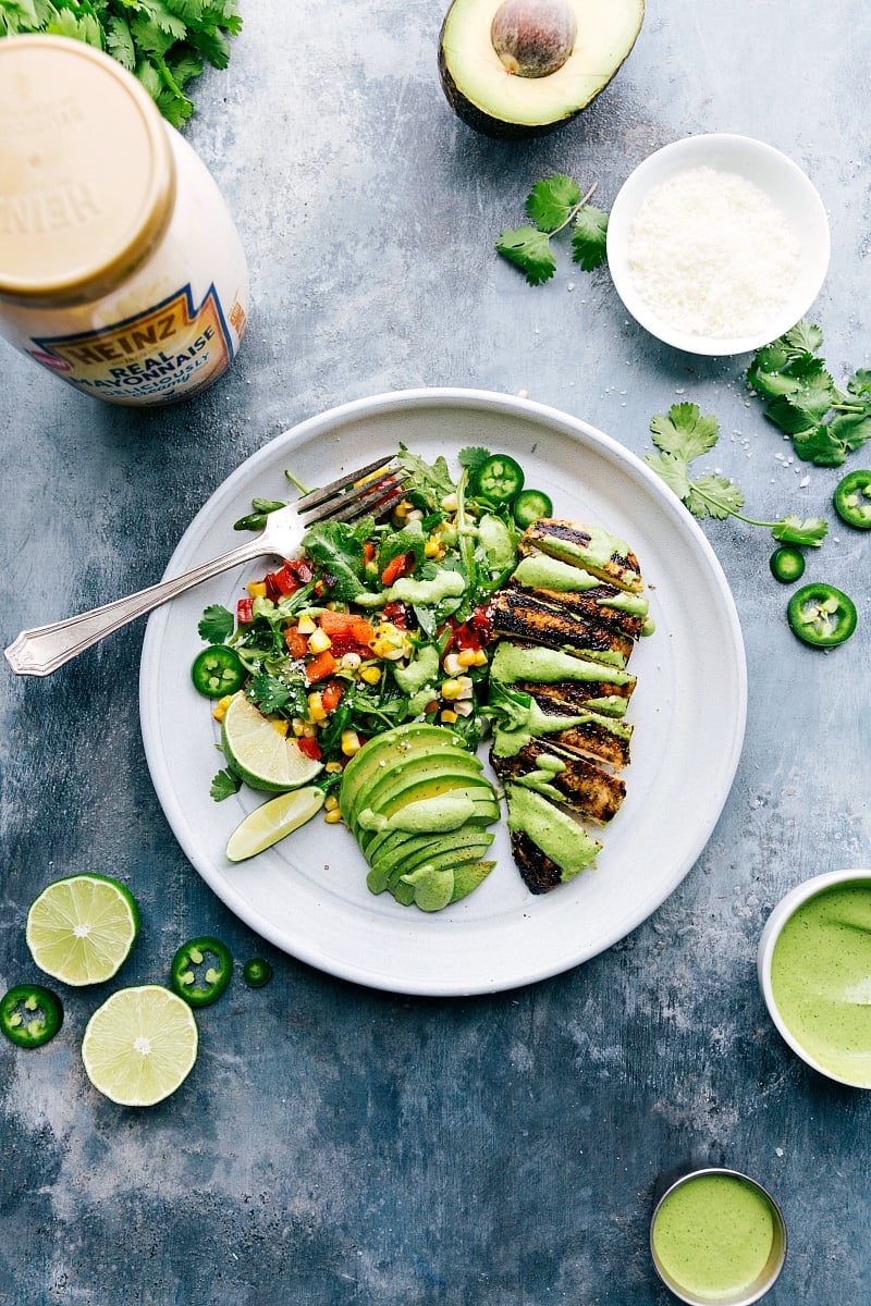 Sliced Peruvian Chicken served with a fresh arugula salad, avocado slices, and all of it covered in the flavorful green sauce, a delectable and healthy dish.