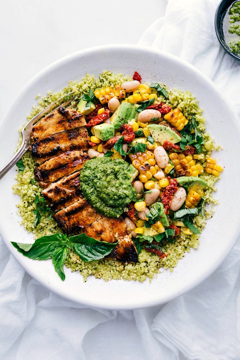 Overhead photo of Pesto Chicken with chicken, corn and white bean salsa, and pesto on top.