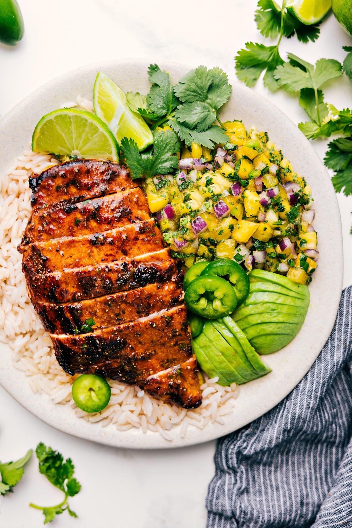 The Best Pineapple Chicken Recipe Pineapple Chicken served over rice with fresh pineapple salsa, avocado, and jalapeño on the side.