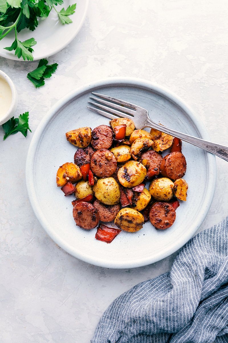Image of the ready-to-eat Sausage and Potatoes Skillet Meal on a plate with a fork.