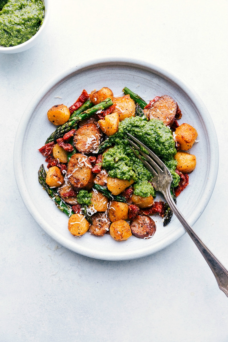 Finished plate of Sausage Pesto and Veggies with a scoop of pesto and fork digging in!