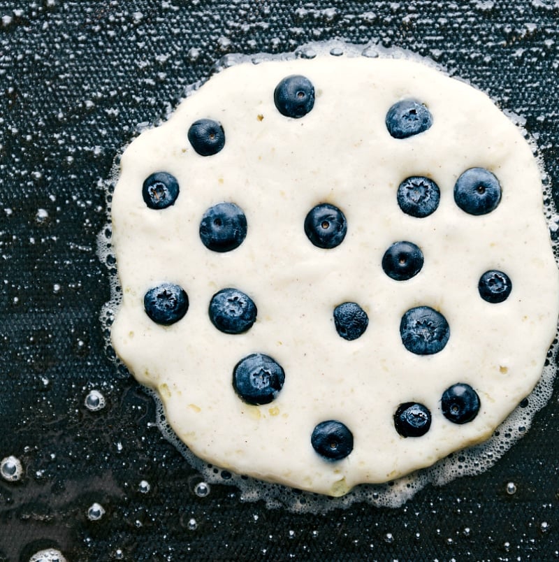 Pancake on the griddle being cooked.