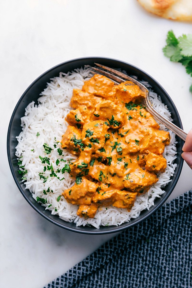 Bowl of Chicken Tikka Masala and rice with a fork digging in!