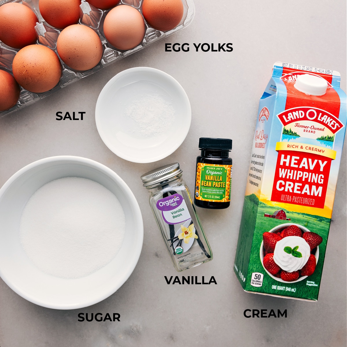 Ingredients spread out for making the creme brûlée recipe, including eggs, sugar, and cream.