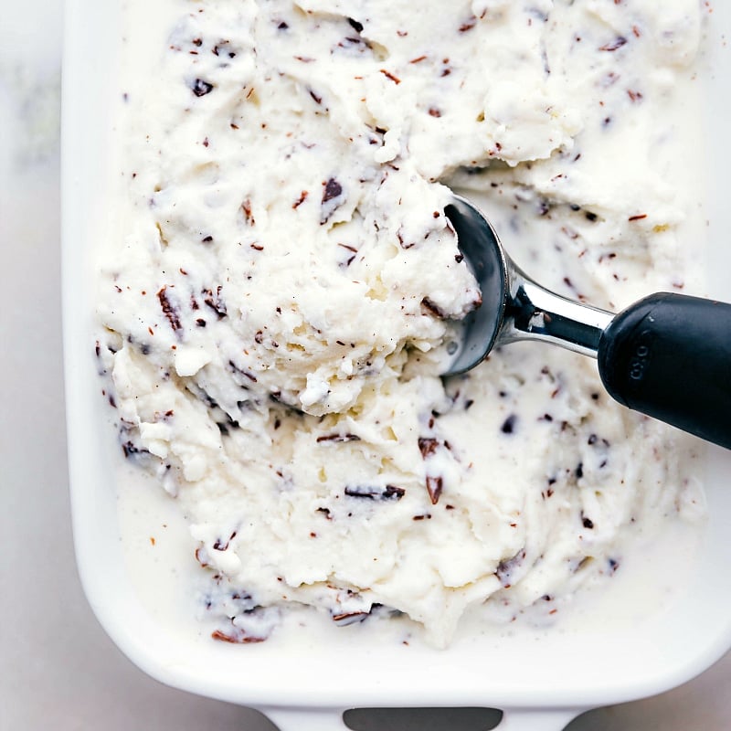 Scooping out a refreshing dessert from the container, full of chocolate chunks and with the perfect creamy texture.