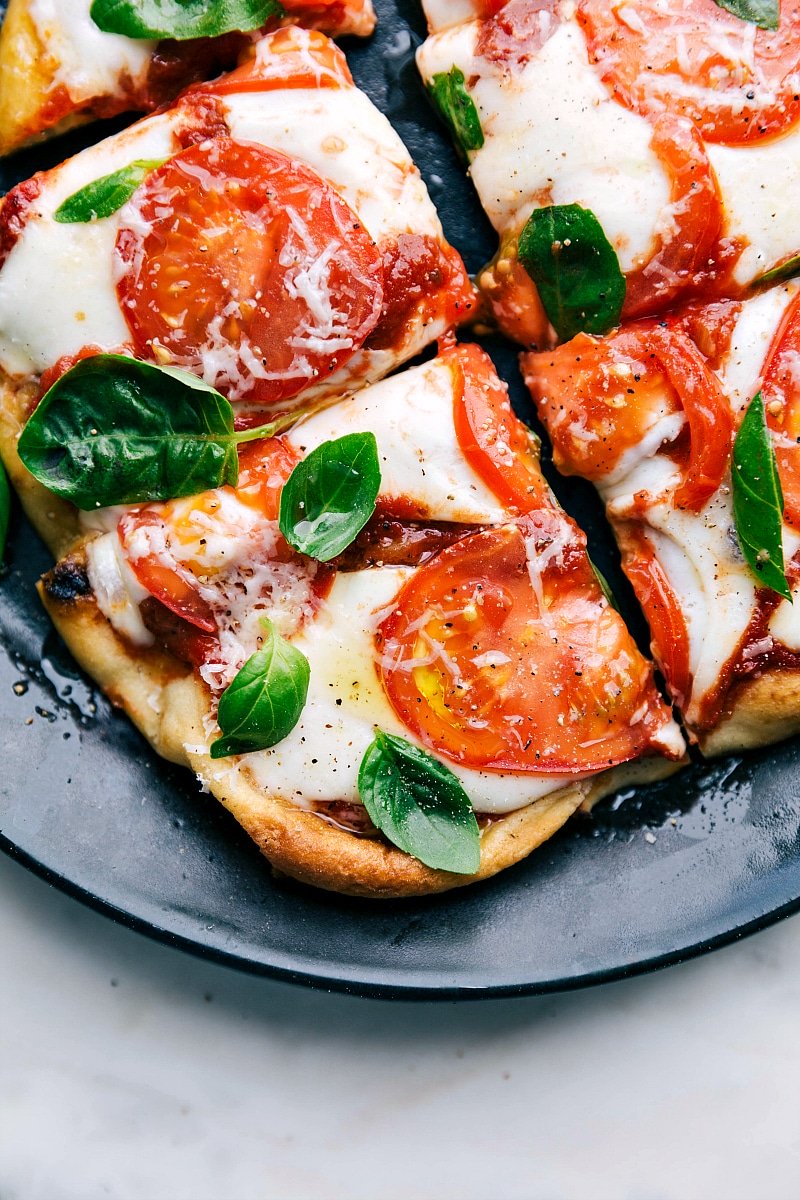 Overhead up-close image of Margherita Pizza cut up into squares and ready to eat.