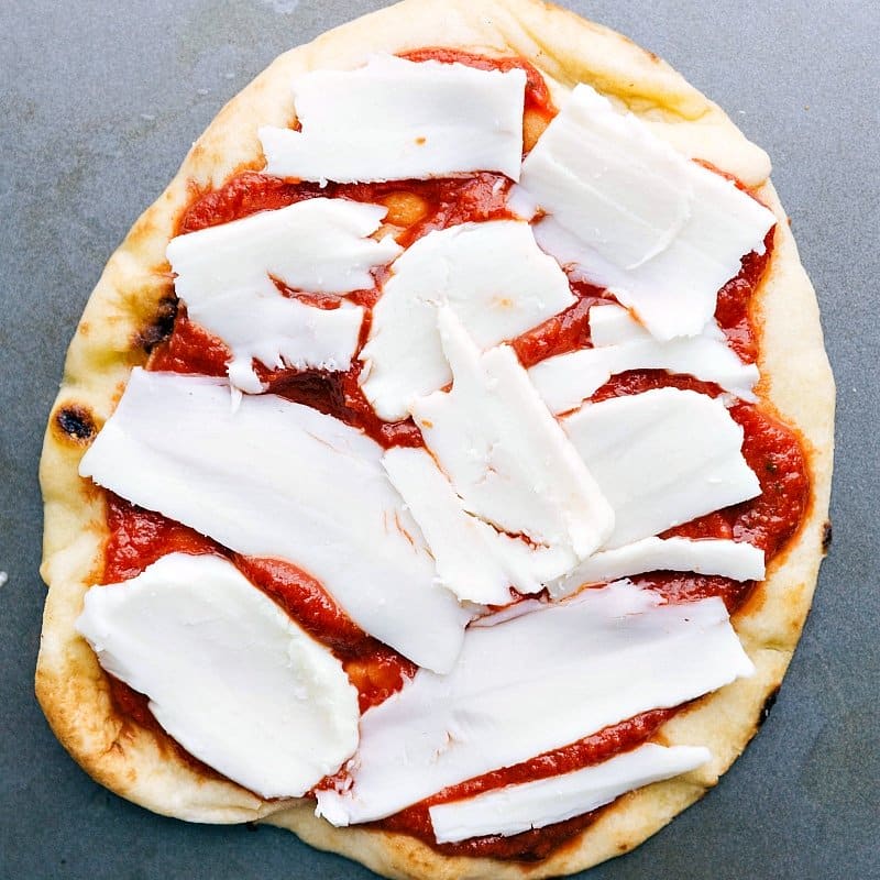 Cheese being added on top of the sauce.