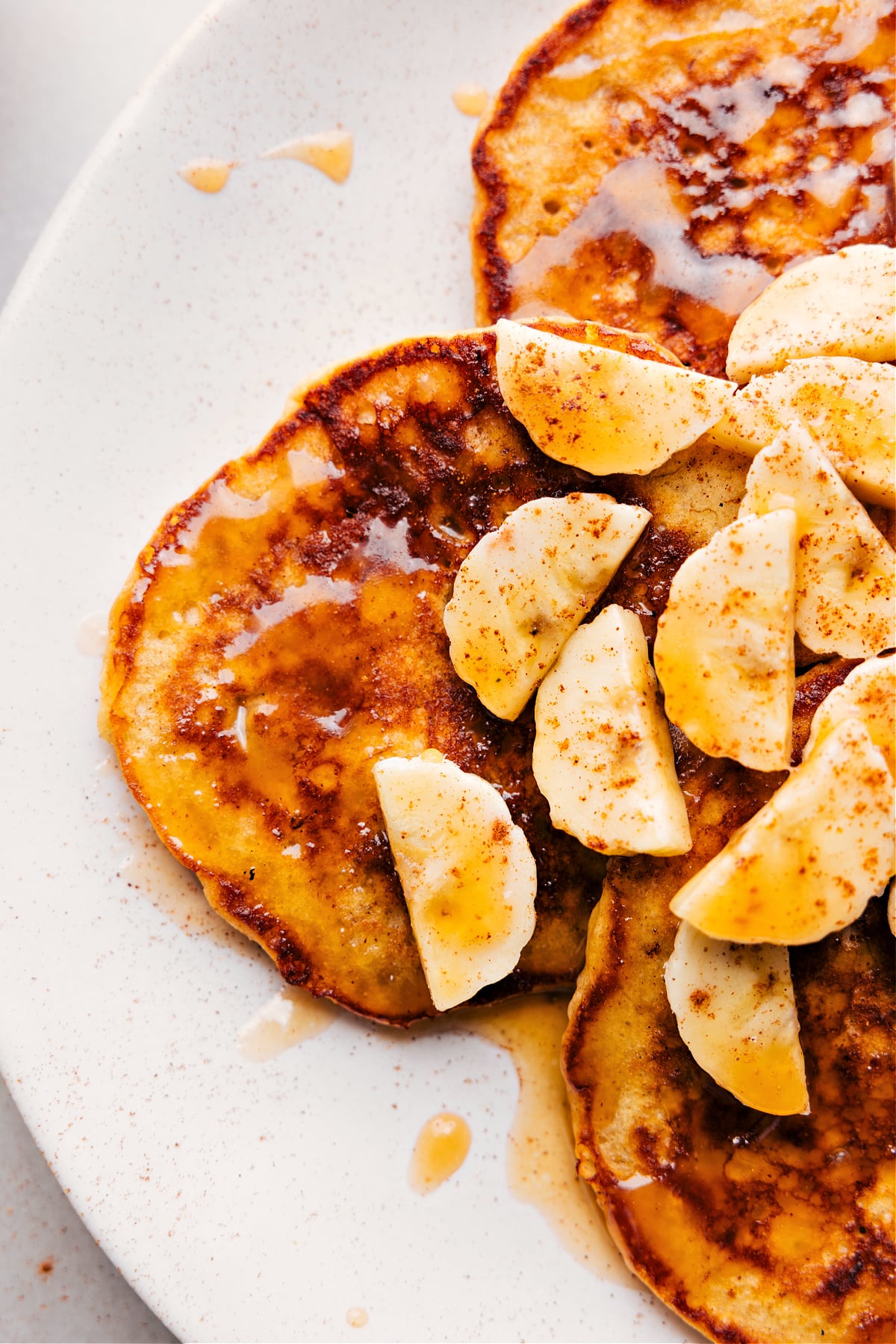 The breakfast straight off the griddle, stacked and ready to be enjoyed, packed full of flavor and topped with syrup.