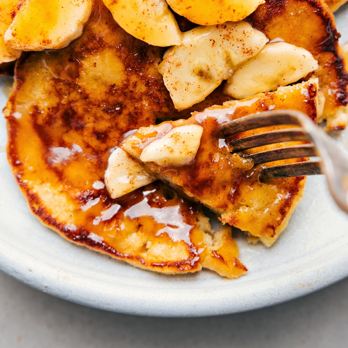 A banana pancake with a bite being taken out of it.