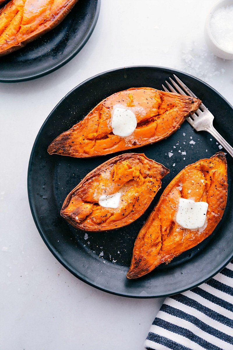 Overhead shot of Baked Sweet Potatoes, ready to eat, on a plate with a fork on the side.