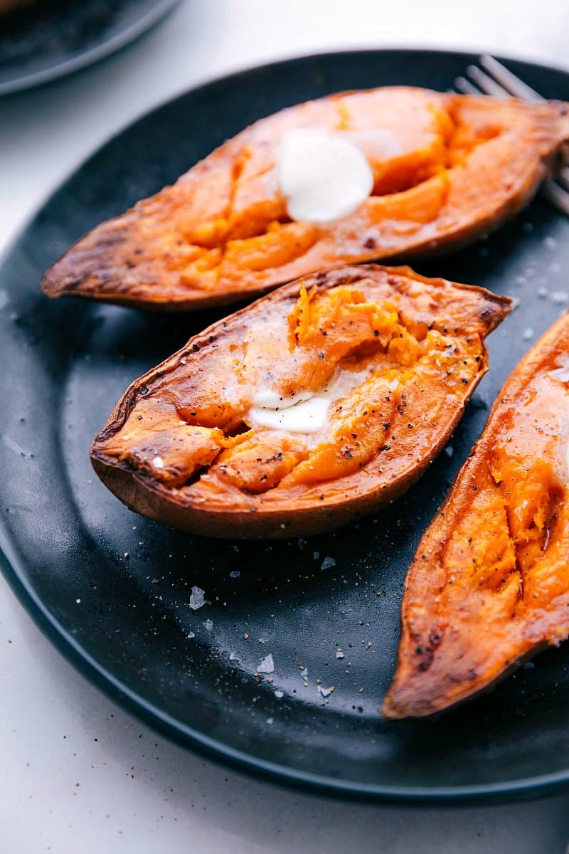 Up-close image of Baked Sweet Potatoes fresh from the oven, with melted butter on top.