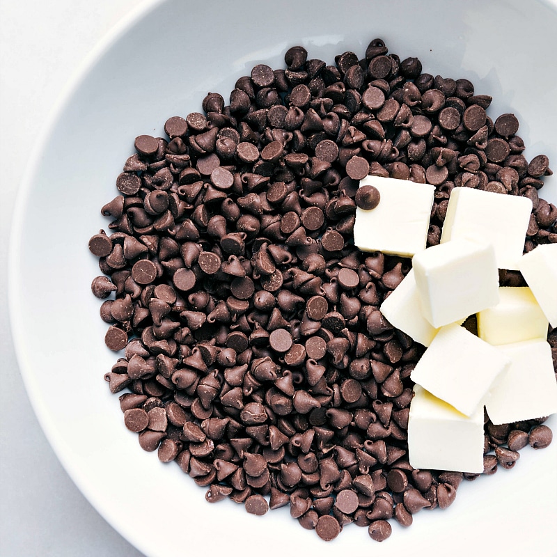 Chocolate chips and butter being added to a bowl for melting as part of this recipe.