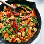Chicken stir fry in a skillet, brimming with vegetables and rich flavors, prepared for serving.