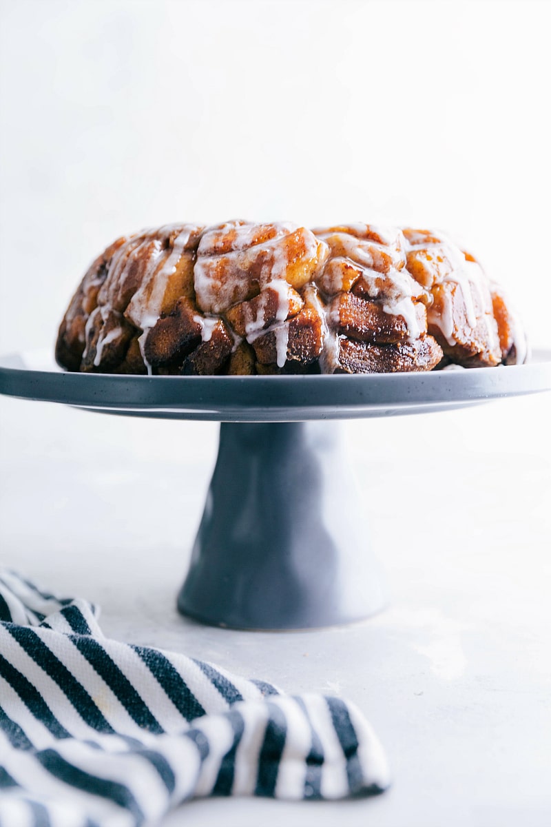 Image of Cinnamon Roll Monkey Bread baked and ready to eat, sitting on a cake stand.