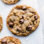 A batch of coconut oatmeal cookies, just out of the oven and baked to perfection, with warm chocolate chips on top, offering a delightful treat.