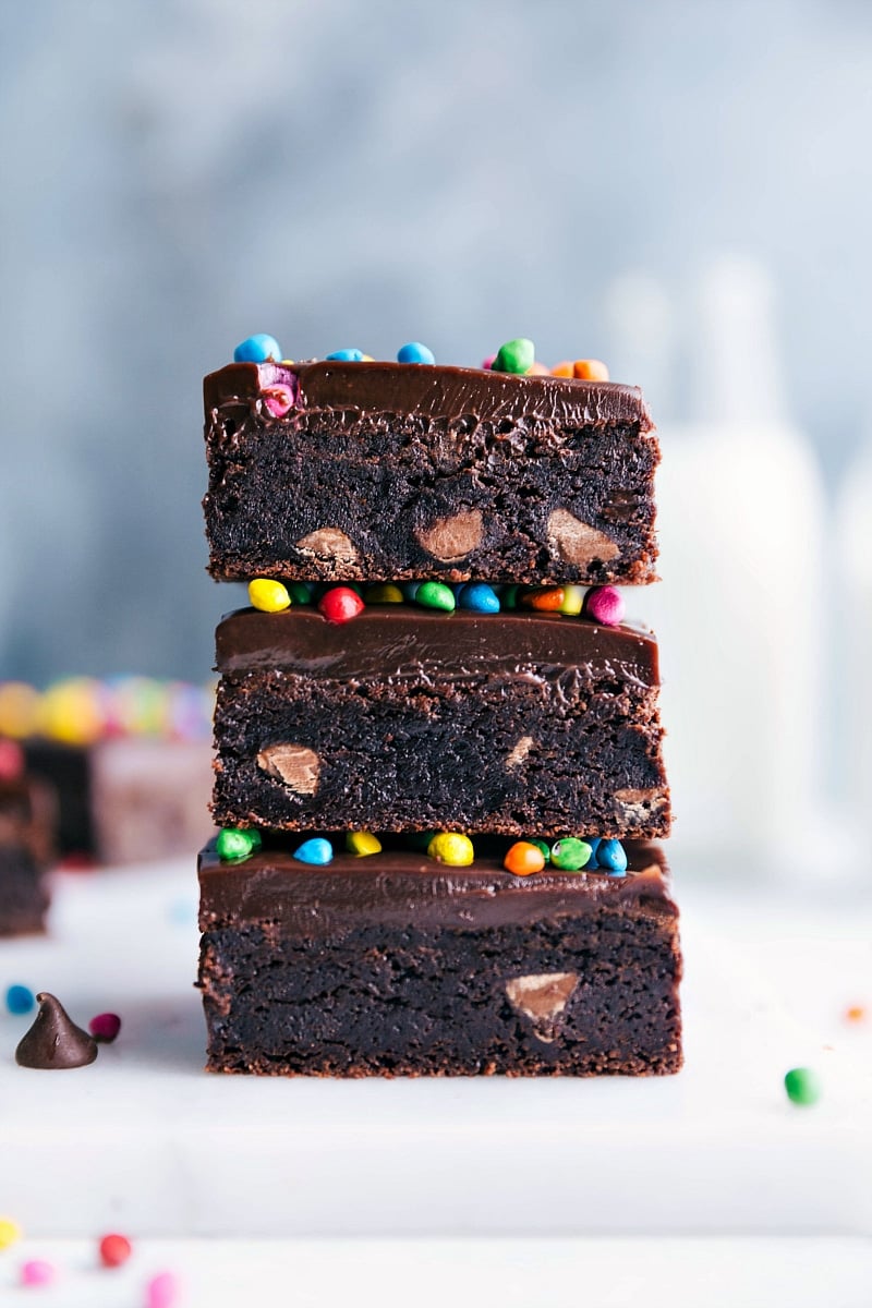 Homemade cosmic brownies stacked, showcasing its delicious layers, and topped with colorful candies - a nostalgic and delicious treat.