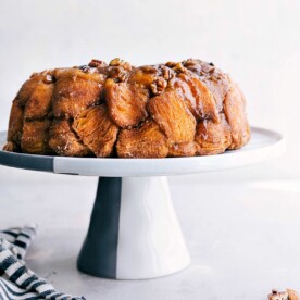 A cake stand showcasing the finished monkey bread, a delicious and sweet dessert or breakfast option that's ready to be enjoyed.