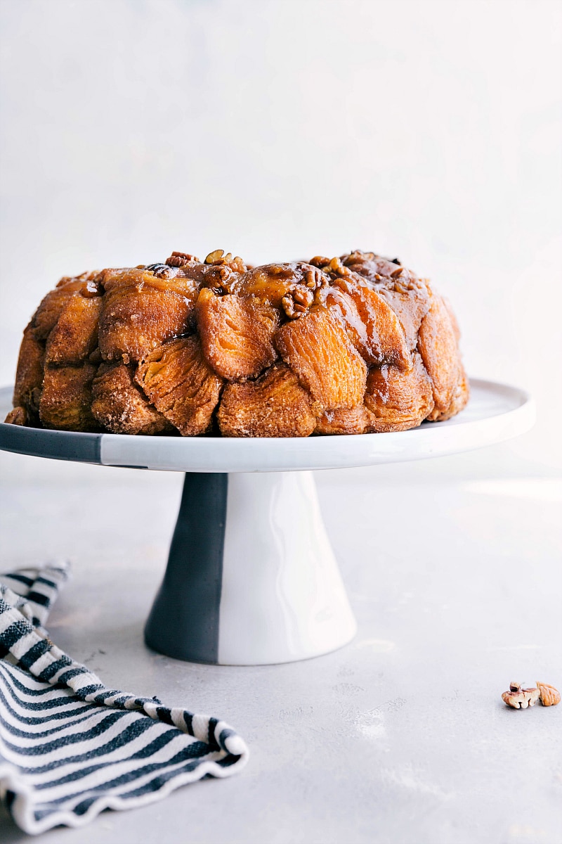 A cake stand showcasing the finished monkey bread, a delicious and sweet dessert or breakfast option that's ready to be enjoyed.