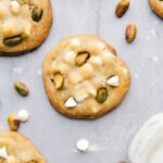 A batch of freshly baked pistachio cookies, baked to a golden-brown perfection, filled with flavor, white chocolate chips, and pistachio bits, ready to be savored.