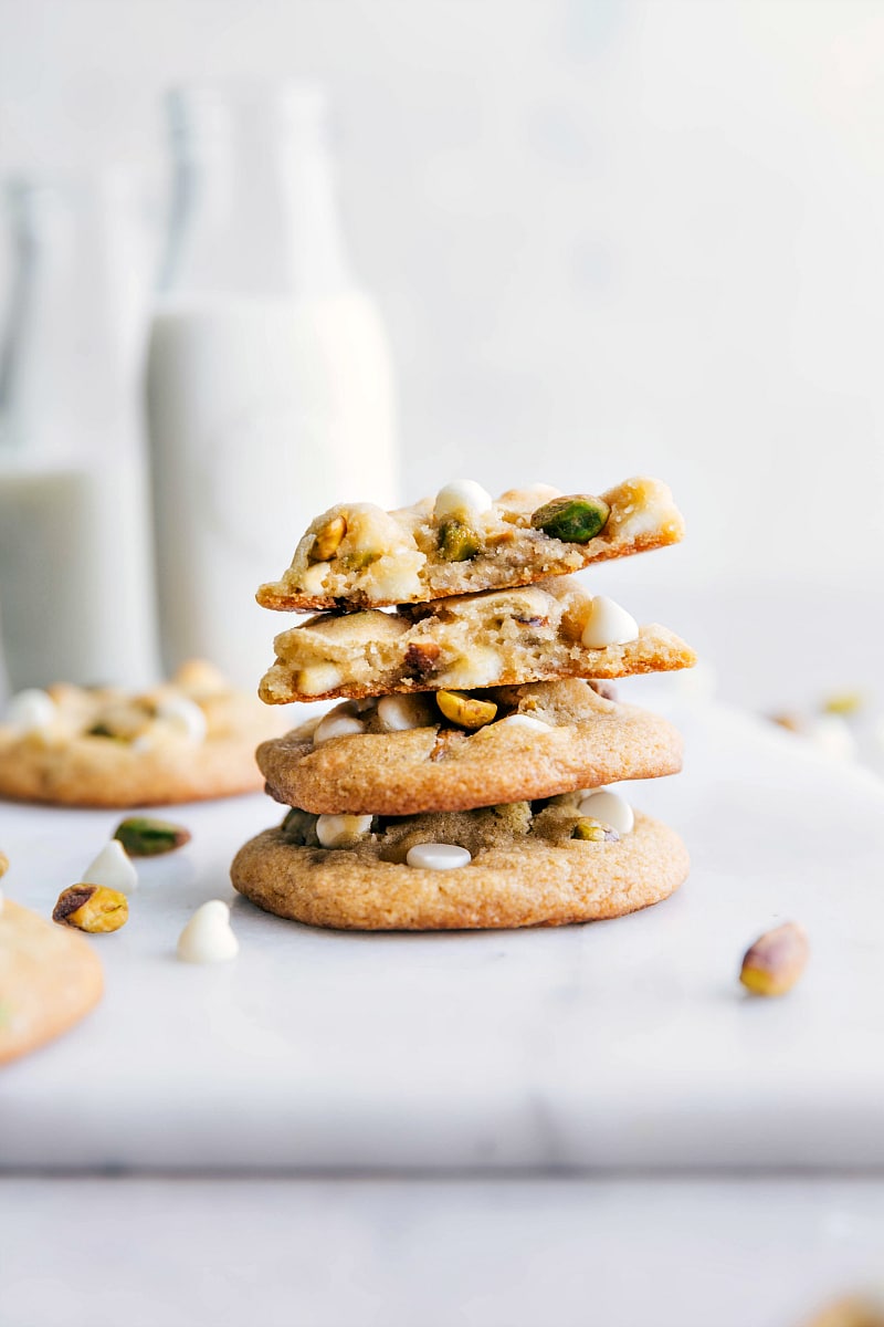 The finished pistachio cookies recipe, with cookies stacked on top of each other and one cookie broken open to reveal its delightful texture and flavor, sure to become a new favorite cookie.