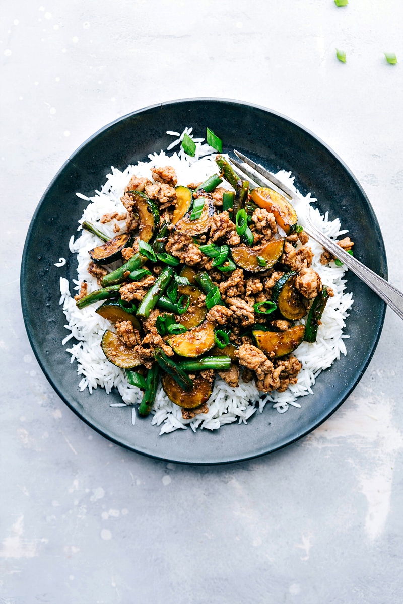 Overhead image of Pork Stir Fry over rice, with a fork on the side, ready to eat.