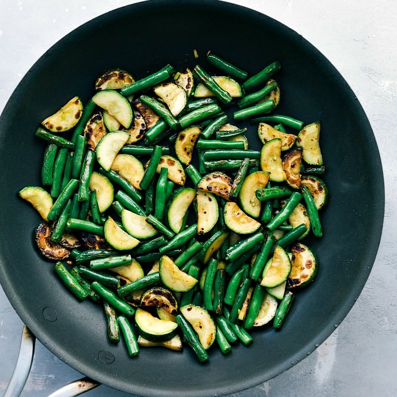 Zucchini and green beans cooked to perfection in a saucepan, tender and flavorful.