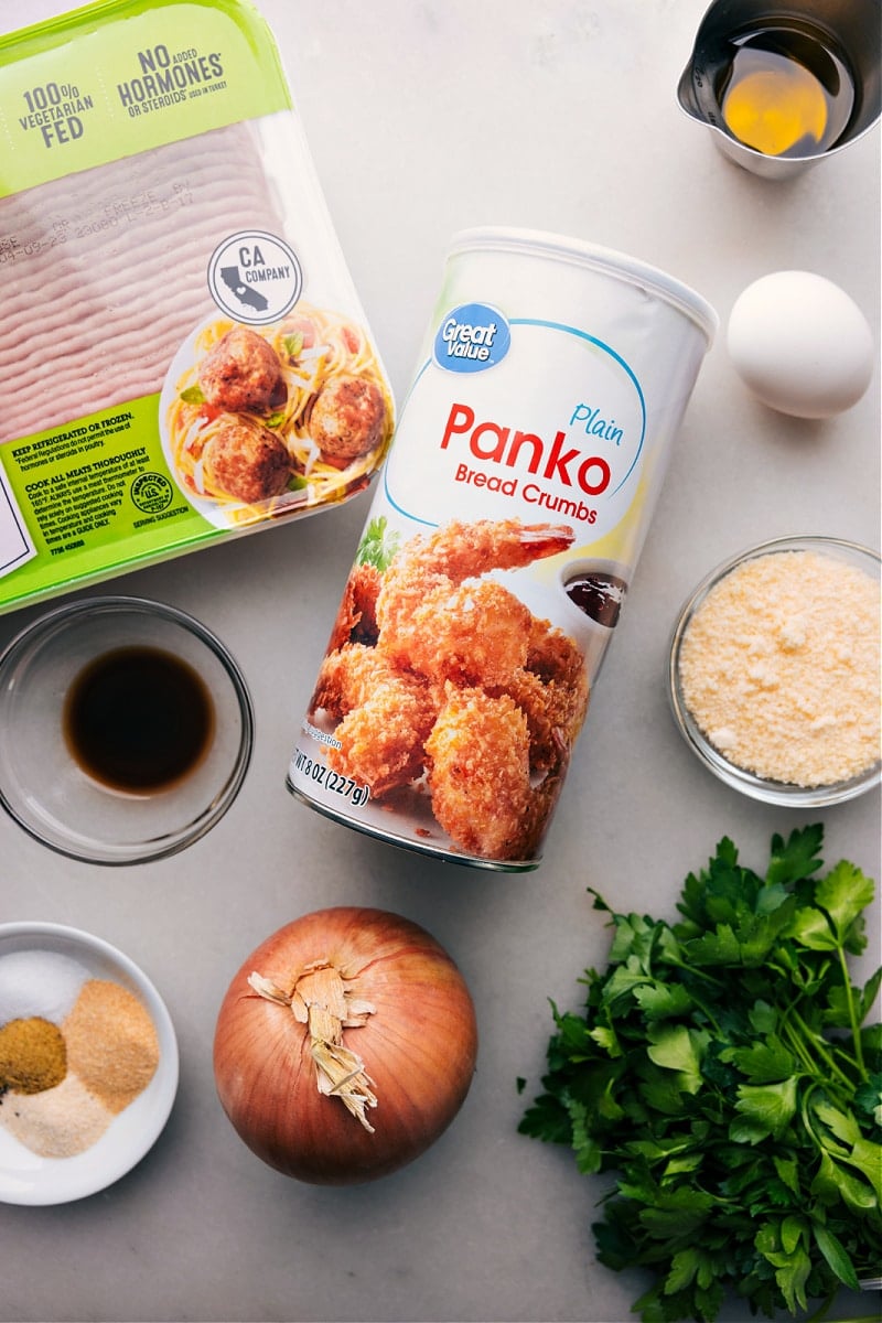 All ingredients for the recipe laid out, including panko, onions, seasonings, meat, and more.
