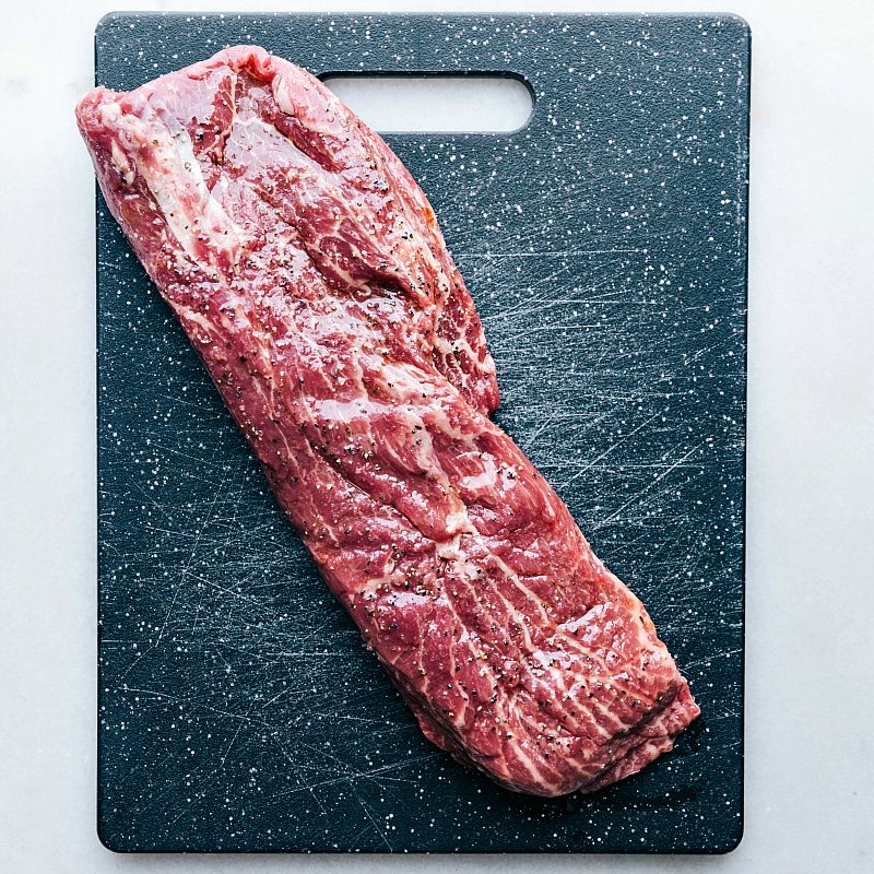 Raw meat arranged on a cutting board, prepared to be seasoned and grilled.