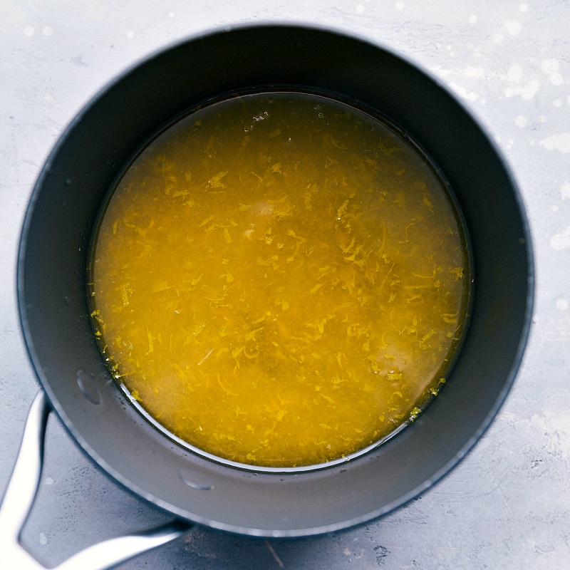 A pan containing freshly made simple orange dressing, steaming and ready to be used, promising to enhance the flavors of the accompanying dish.