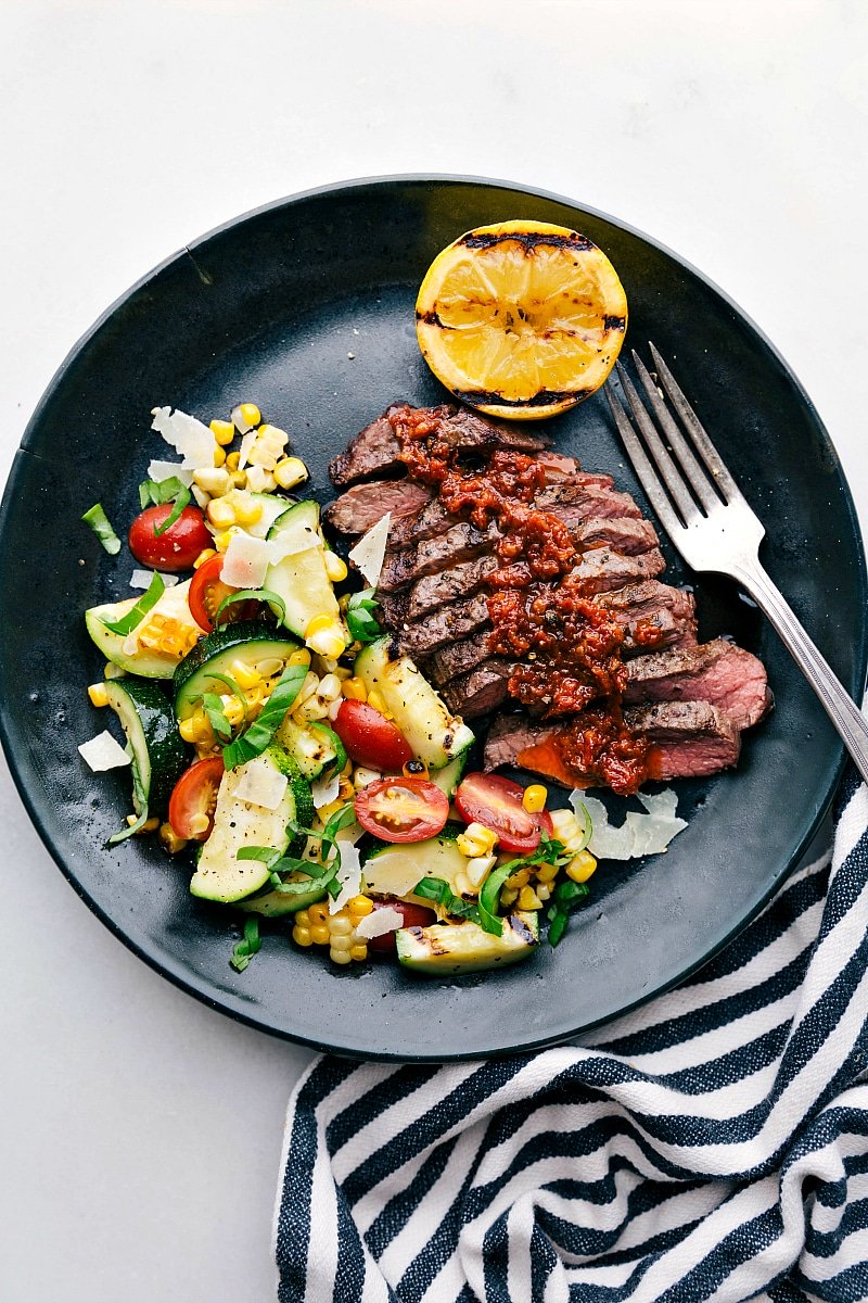 Image of grilled Flat Iron Steak with the zucchini/corn salad on the side.