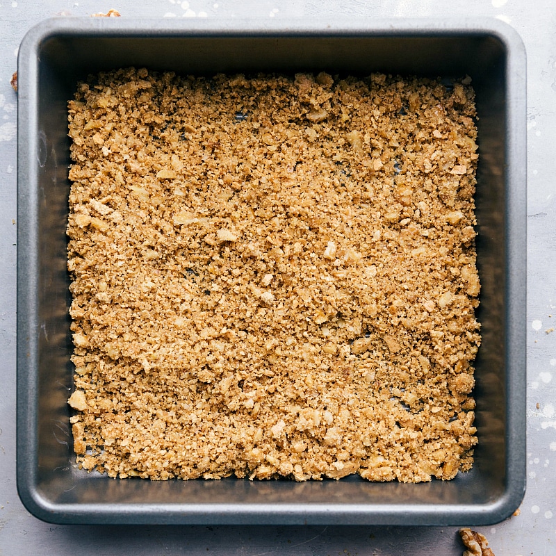 Walnut crumble baking in the oven to achieve a perfect golden-brown finish, adding a delightful crunch to the dessert.