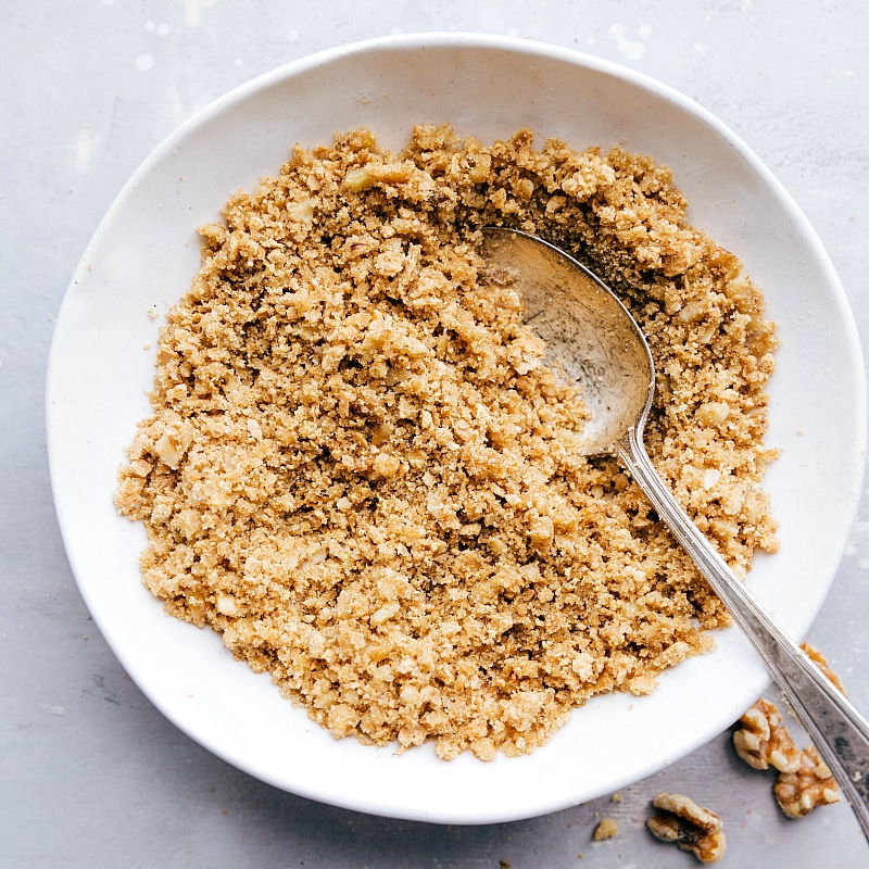 A bowl containing the completed brown sugar and walnut topping, mixed together to perfection, ready to enhance the flavor of the delicious dessert.