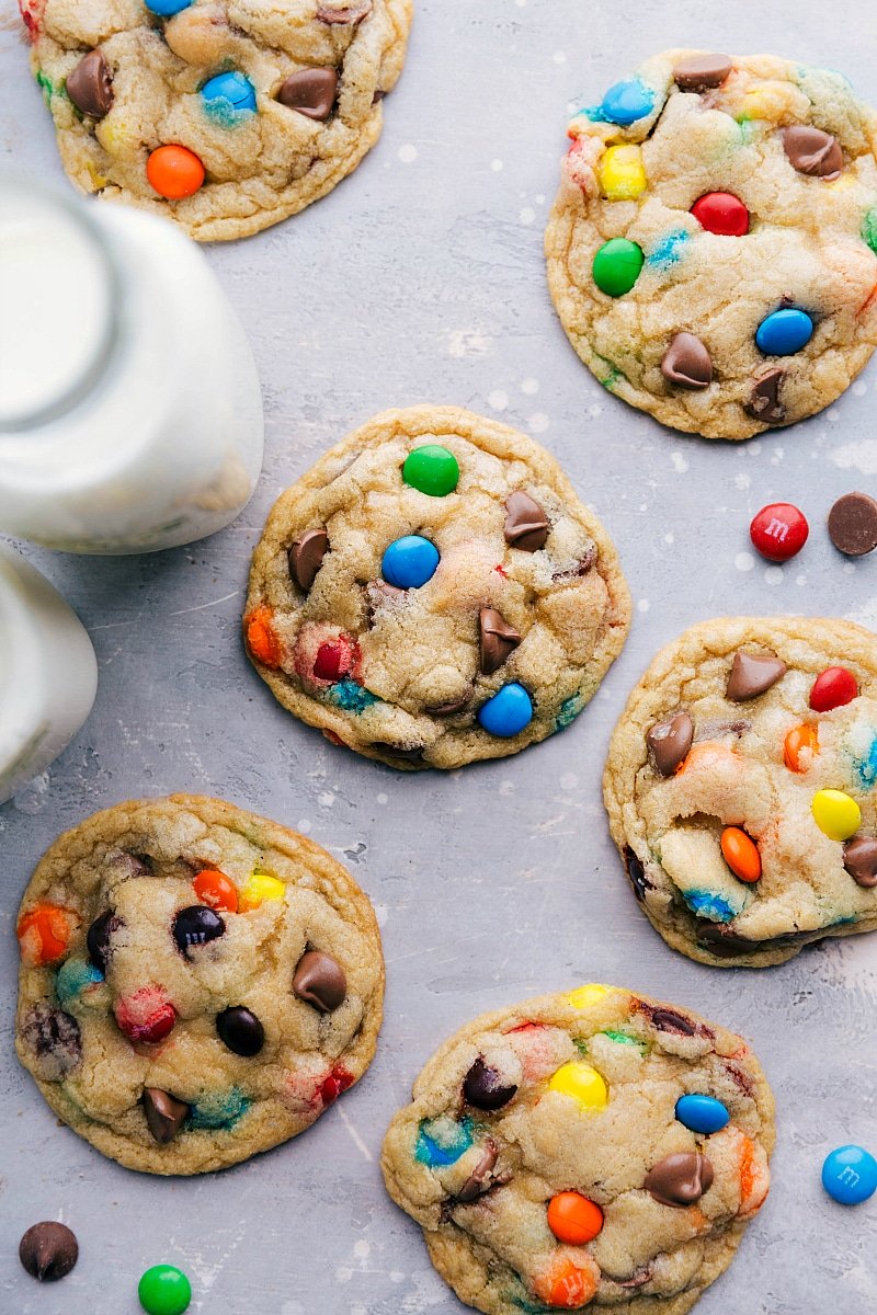 Overhead image of several of the M&M Cookies with milk on the side.