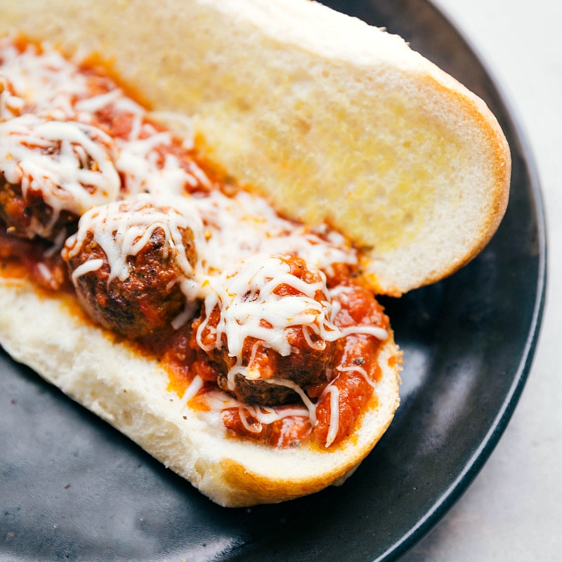 Up-close image of Meatball Subs with melty cheese on top.